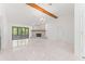 Bright, open living room with white tile flooring, a stone fireplace, and sliding doors to the screened lanai at 10237 Carrin Rd, Spring Hill, FL 34608