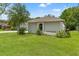 The side yard is well maintained with plush green grass and lush landscaping at 10237 Carrin Rd, Spring Hill, FL 34608