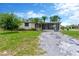 Charming single-story home featuring a large front yard, palm trees and a screened in porch at 11896 104Th Ln, Largo, FL 33773