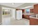 Open floor plan with views of the backyard and kitchen with dark wood cabinets and white appliances at 11896 104Th Ln, Largo, FL 33773