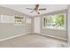 Bright living room with neutral walls, tile floors, and a ceiling fan fixture with views of a tropical landscape at 11896 104Th Ln, Largo, FL 33773