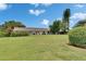 Well-maintained backyard showcasing lush green grass, mature trees, and neatly trimmed hedges at 1214 Haddington Cir # 1214, Sun City Center, FL 33573