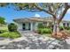 Charming home featuring a well-manicured lawn, mature landscaping, and inviting covered entrance at 1214 Haddington Cir # 1214, Sun City Center, FL 33573