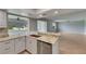 Well-lit kitchen with stainless steel appliances, granite countertops, and an open layout to living area at 1214 Haddington Cir # 1214, Sun City Center, FL 33573