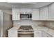 Modern kitchen with stainless steel appliances, granite countertops, and white cabinets at 1214 Haddington Cir # 1214, Sun City Center, FL 33573