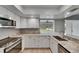 Stylish kitchen featuring granite countertops, white cabinetry, stainless steel appliances, and a breakfast bar at 1214 Haddington Cir # 1214, Sun City Center, FL 33573