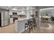 Modern kitchen with stainless steel appliances, white cabinets, granite countertops, and an adjacent breakfast bar at 1214 Haddington Cir # 1214, Sun City Center, FL 33573