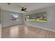 Bright living room with wood floors, a ceiling fan, and large windows at 1214 Haddington Cir # 1214, Sun City Center, FL 33573