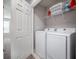Bright laundry room featuring a full-size washer and dryer and functional shelving for convenient storage at 1218 Grantham Dr, Sarasota, FL 34234