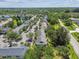 Aerial view of townhouses, lake, lush trees, and parking under a bright, sunny sky at 12472 Country White Cir, Tampa, FL 33635