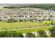 Aerial view of a neighborhood featuring homes with large yards, well-maintained landscaping, and a community pond at 12643 Shetland Walk Dr, Lithia, FL 33547