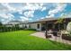 Fenced backyard with a paver patio, pergola, outdoor seating, and lush lawn at 12643 Shetland Walk Dr, Lithia, FL 33547