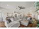 Spacious living room with hardwood floors, a sectional sofa, and an open view to the kitchen and dining at 12643 Shetland Walk Dr, Lithia, FL 33547