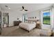 Serene main bedroom featuring neutral tones, plush carpeting, and large windows offering backyard views at 12643 Shetland Walk Dr, Lithia, FL 33547