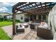 Paver patio with a pergola, outdoor seating, grill, and dining area, creating an inviting outdoor space at 12643 Shetland Walk Dr, Lithia, FL 33547