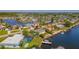 Aerial view of a waterfront property with canal access, pool, and well-kept landscaping at 12829 3Rd Isle, Hudson, FL 34667