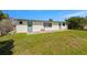 A lovely green backyard space is adjacent to the home's exterior with 2 doors and one window at 12829 3Rd Isle, Hudson, FL 34667