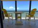 Enjoy the ocean view from this balcony with yellow Adirondack chairs and a bar-height table at 14950 Gulf Blvd # 902, Madeira Beach, FL 33708