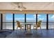 Cozy balcony with comfortable chairs and a table overlooking a breathtaking ocean view at 14950 Gulf Blvd # 902, Madeira Beach, FL 33708