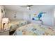 Coastal bedroom featuring two beds with decorative comforters, TV and ceiling fan at 14950 Gulf Blvd # 902, Madeira Beach, FL 33708