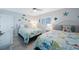 Bright bedroom with two beds with decorative comforters, ceiling fan and shuttered window at 14950 Gulf Blvd # 902, Madeira Beach, FL 33708