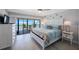 Bright bedroom features a balcony with ocean views, a ceiling fan, and beach-themed decor at 14950 Gulf Blvd # 902, Madeira Beach, FL 33708