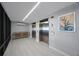 Hallway with a wooden console, two stainless steel elevators and wall art, featuring a tile floor at 14950 Gulf Blvd # 902, Madeira Beach, FL 33708