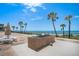 Outdoor grilling area with brick smoker and dining space, set against an ocean backdrop with palm trees at 14950 Gulf Blvd # 902, Madeira Beach, FL 33708