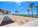 Outdoor shuffleboard court with ocean views and swaying palms; a tranquil community recreation space at 14950 Gulf Blvd # 902, Madeira Beach, FL 33708