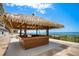 Outdoor tiki bar with a wooden frame and thatched roof offers stunning views of the ocean and the sky at 14950 Gulf Blvd # 902, Madeira Beach, FL 33708