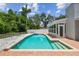 Backyard featuring a pool, privacy fence, shed and sunroom at 15108 Winterwind Dr, Tampa, FL 33624