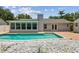 Backyard pool and privacy fence with a shed and white rock landscaping at 15108 Winterwind Dr, Tampa, FL 33624