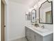 This bathroom features an updated vanity with double sinks, decorative mirrors, and modern lighting at 15108 Winterwind Dr, Tampa, FL 33624