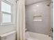 The bathroom features a tub/shower combination with gray tile, a niche, and a white shower curtain at 15108 Winterwind Dr, Tampa, FL 33624