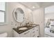 Stylish bathroom with double vanity, granite countertop, modern fixtures, and oval mirrors at 15108 Winterwind Dr, Tampa, FL 33624