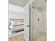 Elegant bathroom with a frameless glass shower and view into the Primary bedroom at 15108 Winterwind Dr, Tampa, FL 33624