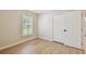 This bedroom has wood-look tile floors, a window that lets in natural light, and a closet with white doors at 15108 Winterwind Dr, Tampa, FL 33624
