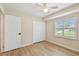 This bedroom features wood-look tile floors, a ceiling fan, a closet, and a window for natural light at 15108 Winterwind Dr, Tampa, FL 33624