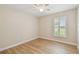 This bedroom is painted in a neutral color, has wood-look tile floors, and a window that lets in natural light at 15108 Winterwind Dr, Tampa, FL 33624