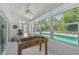 Bright bonus room featuring a foosball table, white shiplap walls, herringbone tile floors, and view of the pool at 15108 Winterwind Dr, Tampa, FL 33624
