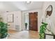 Welcoming entryway with wood-look tile, complemented by a rich, paneled front door and tasteful decor at 15108 Winterwind Dr, Tampa, FL 33624