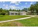Cozy single-Gathering home showcases a wide lawn, a paved driveway, and an attached two-car garage at 15108 Winterwind Dr, Tampa, FL 33624