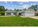 Inviting one-story home with a green lawn, complemented by a driveway and a convenient two-car garage at 15108 Winterwind Dr, Tampa, FL 33624