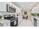 Modern kitchen featuring stainless steel appliances, white cabinetry, and a cozy breakfast nook at 15108 Winterwind Dr, Tampa, FL 33624