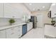Well-lit kitchen with white cabinets, subway tile backsplash, and stainless steel appliances at 15108 Winterwind Dr, Tampa, FL 33624