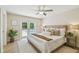 Comfortable main bedroom with ceiling fan, light rug, and backyard view through French doors at 15108 Winterwind Dr, Tampa, FL 33624