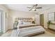 A well-lit main bedroom with a ceiling fan, soft rug, and comfortable queen bed at 15108 Winterwind Dr, Tampa, FL 33624