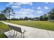 A serene park features a bench and a wide expanse of green space under a partly cloudy blue sky at 15108 Winterwind Dr, Tampa, FL 33624