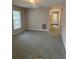 Neutral living area featuring carpet, a window, and views of the entry hallway at 159 6Th Nw St, Largo, FL 33770