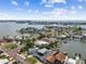 Panoramic aerial showcases waterfront community with homes, private docks, and bay access, highlighting coastal living at 16106 6Th E St, Redington Beach, FL 33708